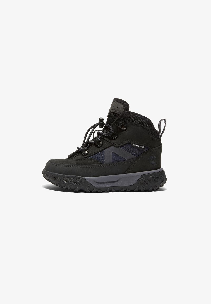 Botte de randonnée Timberland noire avec semelle épaisse, laçage à l’avant et col rembourré autour de la cheville, montrée en profil latéral sur fond blanc.