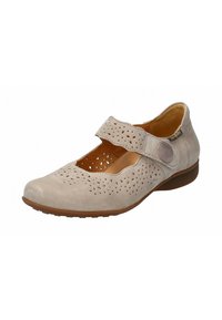 Zapato tipo Mary Jane beige, hecho de un material sintético suave, con parte superior perforada, punta redonda y correa ajustable con un acento circular. Suela marrón.