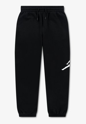 Pantalon de survêtement noir avec taille élastique, cordon de serrage, bas élastiqués et un motif silhouette blanc partiel sur la jambe droite.