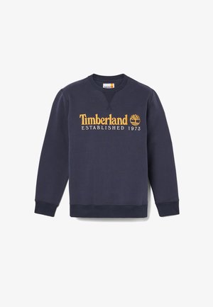 Sweatshirt bleu marine avec col rond à côtes, manches longues et logo brodé "Timberland ÉTABLI 1973" en doré sur la poitrine.