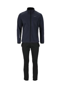 Veste bleu marine foncé avec col montant, fermeture éclair sur le devant et accents réfléchissants, associée à un pantalon noir à coupe ajustée et avec des poignets élastiques.