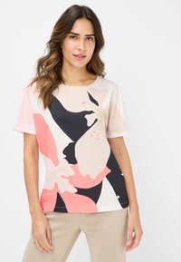 Korte ærmer top med blomsterprint i blødt stof; har nuancer af pink, sort og creme; rund halsudskæring og afslappet pasform.