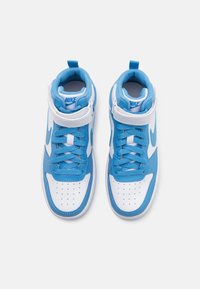 High-top sneakers in blue and white leather with perforated toe, lace-up design, and velcro strap. Features Nike logo in light blue.