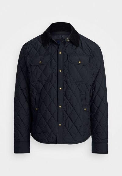 Veste noire matelassée avec un col en velours côtelé, deux poches poitrine et des boutons-pression dorés. Dotée d'une finition texturée et isolée.