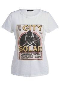 Camiseta de algodón blanca con un estampado gráfico de estilo vintage en negro y amarillo, que muestra los detalles del evento y un diseño de silueta.
