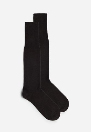 Schwarze knielange Socken aus glattem, dehnbarem Material, mit einem gerippten Bündchen und nahtlosem Zehenbereich für zusätzlichen Komfort.