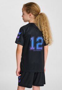 Zwarte sporttrui met korte mouwen, voorzien van paarse en blauwe accenten, het nummer 12 op de achterkant en de tekst "VERLICHT DE WERELD."