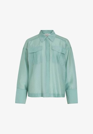 Mündroheline särk-jakk, kerge satiinimaitsega, millel on nööbiga eesmine osa, kaks rinna taskut ja pikad varrukad laia mansetiga.