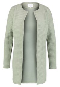 Světle zelený svetr s texturovaným tkaným vzorem, otevřený přední díl a dlouhé rukávy. Měkká tkanina, bez zapínání a s čistým výstřihem.