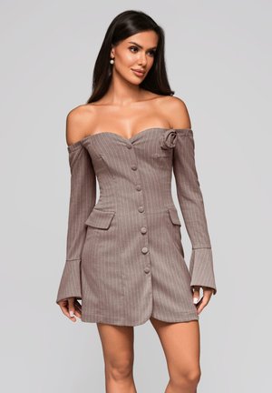 Frau trägt ein schulterfreies, langärmliges taubenblaues Kleid mit Nadelstreifen, vorderen Knöpfen und einer Stoffblume auf der Brusttasche.