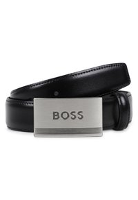 Μαύρη δερμάτινη ζώνη με ασημένια ορθογώνια αγκράφα που φέρει το ανάγλυφο όνομα της μάρκας "BOSS" και οριζόντιες γραμμές στην κάτω άκρη.