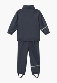 Marine waterdichte jas en broek set. De jas heeft een hoge kraag, elastische manchetten en reflecterende strepen. De broeken hebben verstelbare enkelriemen.