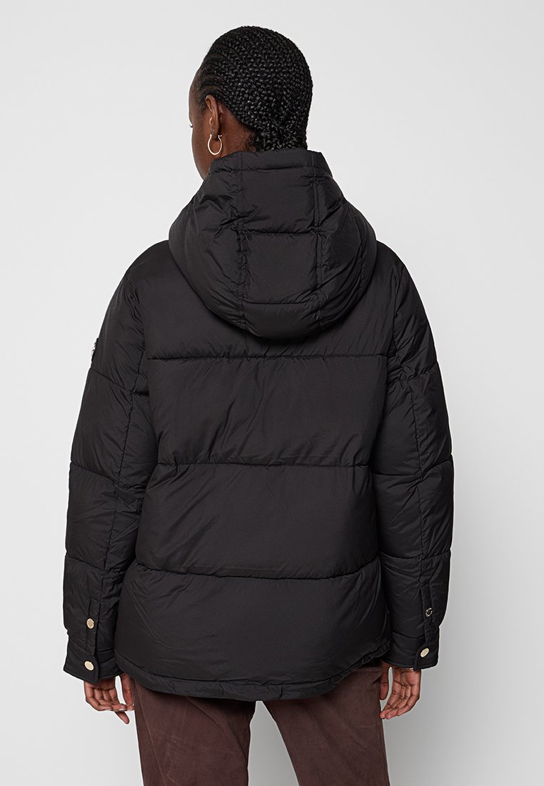 Chaqueta de plumas negra con capucha, diseño acolchado y detalles de botones a presión. Presenta un ajuste holgado y una textura suave para mayor calor.