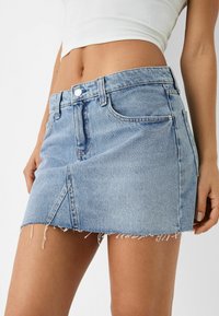 Vaaleansininen farkkuinen minihame, jossa on purjeet, etutaskut ja napitus. Hameessa on ihonmyötäinen muotoilu ja hieman joustavaa materiaalia.