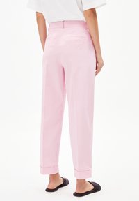 Roze wijde broek met een zachte textuur, met een medium taille, achterzakken en omgeslagen boorden, gecombineerd met zwarte instappers.