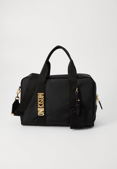 Schwarze Nylon-Tasche mit goldfarbenen Beschlägen, doppelten Obergriffen, abnehmbarem Schultergurt und einem Lederanhänger. Rechteckige Form mit Reißverschluss.