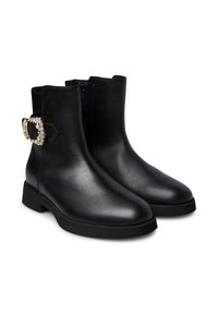 Stivali alla caviglia in pelle nera con finitura liscia, punta arrotondata, tacco basso a blocco e fibbia decorativa con strass sul lato.
