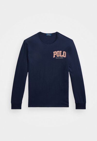 Námořnická košile s dlouhými rukávy vyrobená z bavlny. Obsahuje kulatý výstřih a výrazné logo "POLO" v oranžové barvě na levé straně hrudi.