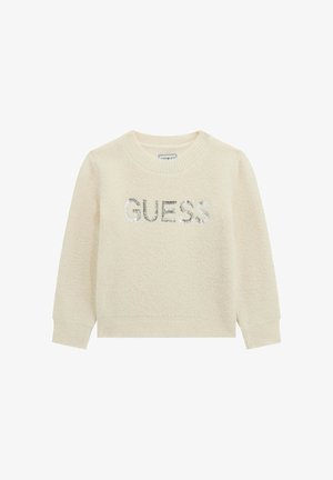 Maglione color crema con una consistenza soffice, caratterizzato da un logo "GUESS" in paillettes argentate sul petto e polsini e scollatura a coste.