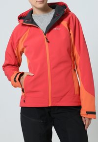 Veste softshell rouge et orange avec capuche, fermeture éclair frontale et poches latérales. Caractérisée par des accents noirs aux poignets et une texture lisse.