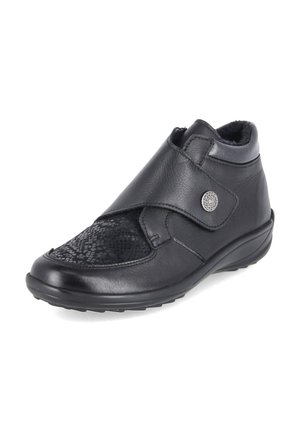 Chaussure à cheville en cuir noir avec bride ajustable, panneau avant texturé, doublure douce et semelle plate basse pour une marche confortable.