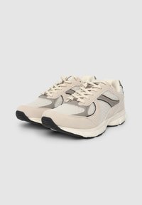 Scarpe sportive in rete e suede beige con accenti grigi, chiusura con lacci e suola in gomma nera, caratterizzate da punta arrotondata e colletto imbottito.