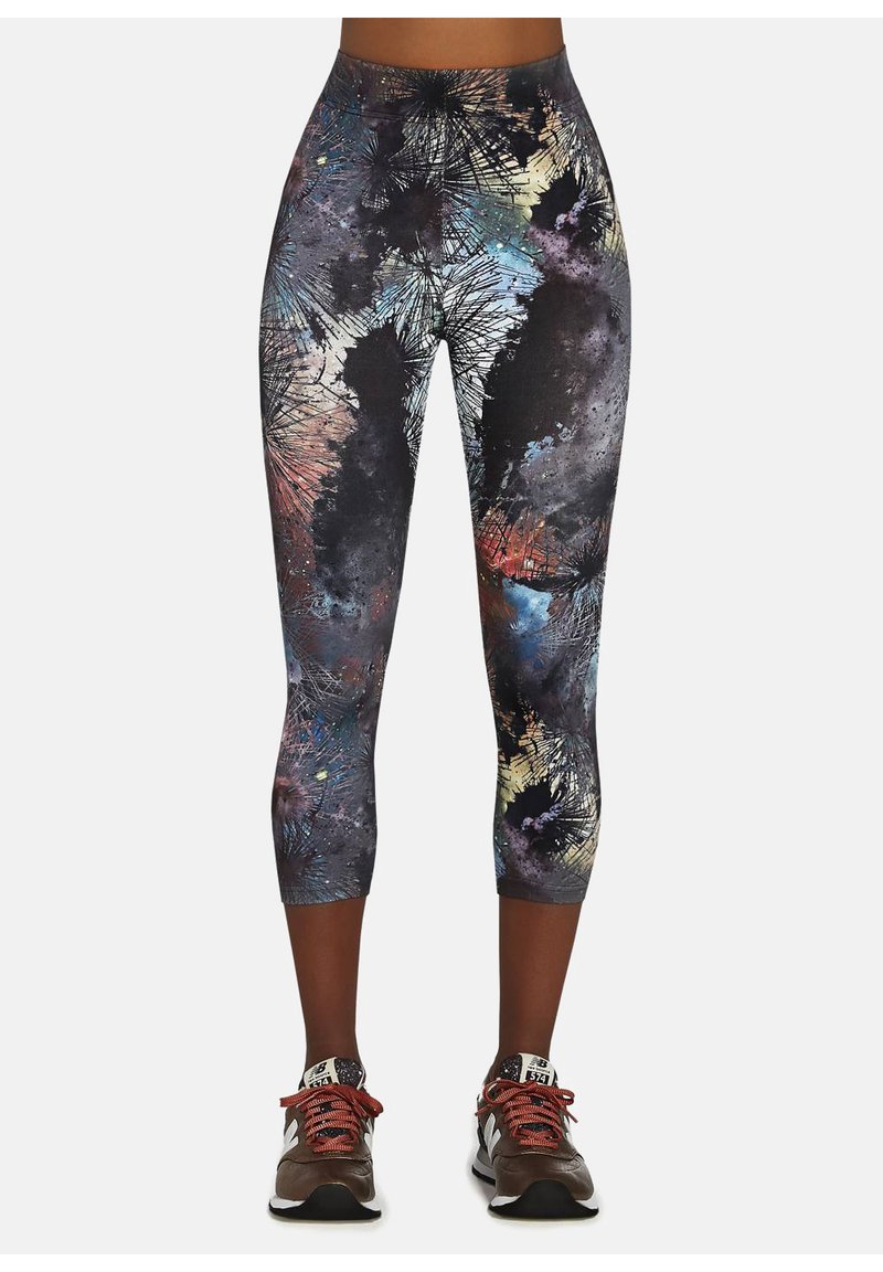 Kolorowe, dopasowane legginsy typu capri z abstrakcyjnymi, wielokolorowymi wzorami na czarnym tle. Wysoki stan dla wygody.