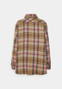 Chemise en flanelle à manches longues à carreaux jaune, marron et rose, vue de dos avec col et poignets boutonnés.