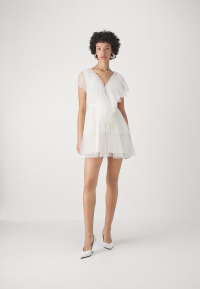 Witte tule jurk met gelaagde tiered-lagen, kap mouwen en een V-halslijn. Beschikt over delicate ruches en een lichtgewicht, transparante textuur.