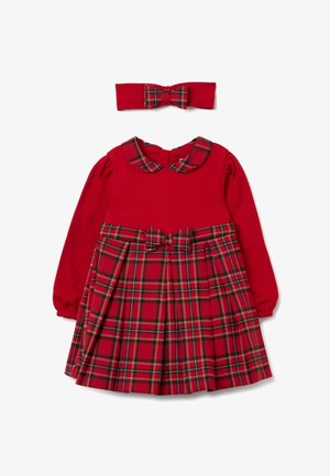 Vestito rosso a maniche lunghe con gonna plissettata a quadri e collo arrotondato; fascia per capelli rossa coordinata con dettaglio a fiocco a quadri al centro.