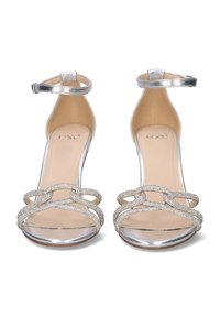 Sandalias de tacón alto plateadas con correas transparentes y parte superior adornada. Cuenta con una correa en el tobillo y un diseño de punta abierta, con un acabado brillante.