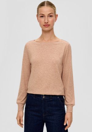 Light pink long-sleeve top made of soft fabric with a round neckline and ribbed cuffs, paired with dark denim jeans.