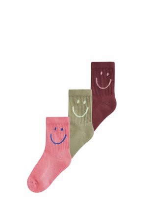 Tre farverige sokker i pink, grøn og bordeaux, hver med et stort smilende ansigt design på den øverste del.