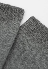 Calze grigie lavorate a maglia con una consistenza morbida, dotate di polsini a coste e una finitura liscia, che mostrano due bordi di calze sovrapposti.