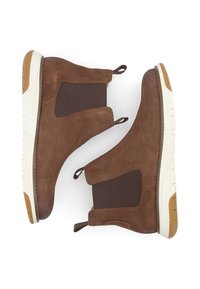 Bottines en daim marron avec des panneaux latéraux élastiques, des languettes de traction et des semelles en caoutchouc blanc avec un accent en caoutchouc marron. Design texturé et polyvalent.