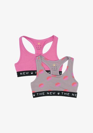 Dos sujetadores deportivos en rosa y gris. El sujetador rosa tiene una textura lisa, mientras que el sujetador gris presenta un estampado de labios. Ambos tienen una banda elástica negra.