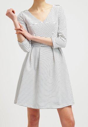 Raidallinen mekko, jossa on V-pääntie, kolmanneksen pituiset hihat ja avara hame. Kangas on kevyt, valkoisella pohjalla ja mustilla raidoilla.