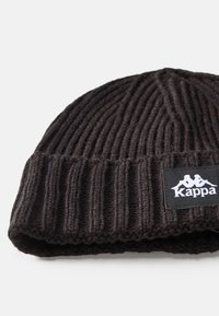 Gorro de punto acanalado negro hecho de material suave, con un dobladillo plegado y una etiqueta rectangular del logo Kappa en blanco y negro.