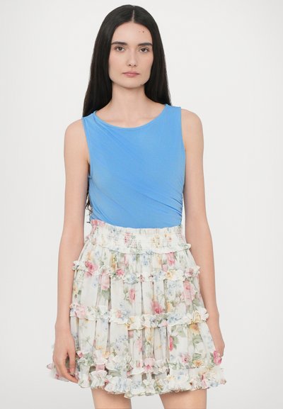 Blue sleeveless top with draped detail paired with a tiered, ruffled floral skirt in pastel colors. Soft fabric with a fitted waistband.