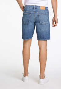 denim shorts met een lichtblauwe wassing, rechte snit, vijf-pocket ontwerp en een leren label op de achterkant van de tailleband.