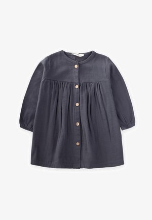 Robe bleu marine en tissu doux, avec un col rond, des détails froncés, des manches longues et des boutons en bois sur le devant.