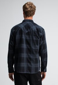 Geruite shirt in donker marineblauw en zwarte tinten, met knoopsluiting bij de mouwen, zacht materiaal met een gestructureerde afwerking en een puntige kraag.