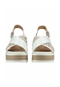Sandali platform bianchi con cinturini incrociati, dettagli intrecciati e un tacco impilato beige. Pelle liscia e dettagli testurizzati sui lati.