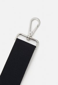 Svart webbing stropp med en sølvfarget metallklips, med en teksturert overflate og en solid festemekanisme for sikker feste.