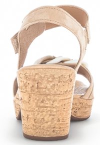 Beżowe sandały na korkowym koturnie z dwiema regulowanymi paskami, z gładką, miękką cholewką i fakturowanym obcasem korkowym.