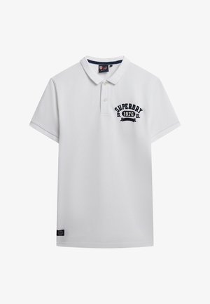 Witte polo shirt van katoen, met een marineblauw geborduurd logo op de linkerkant van de borst en een kraag. Korte mouwen met een rechte onderrand.