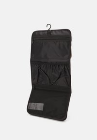 Schwarze organisatorische Reisetasche mit mehreren Reißverschlusstaschen, elastischen Bändern und einem Aufhaken. Verfügt über einen Netzbereich am Boden.