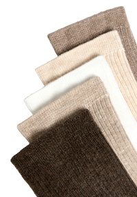 Cinque paia di calzini a costine in vari colori: marrone scuro, marrone chiaro, crema, bianco e beige, che mostrano una morbida texture lavorata a maglia.