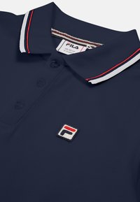 Marinblå polo skjorta i strukturerad tyg, med en tre-knapps knäppning, kontrasterande randig krage och broderad logotyp i hörnet.