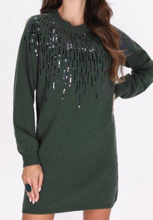 Dark green knit sweater dress with long sleeves and black sequins cascading from the neckline on the upper chest and shoulders.
